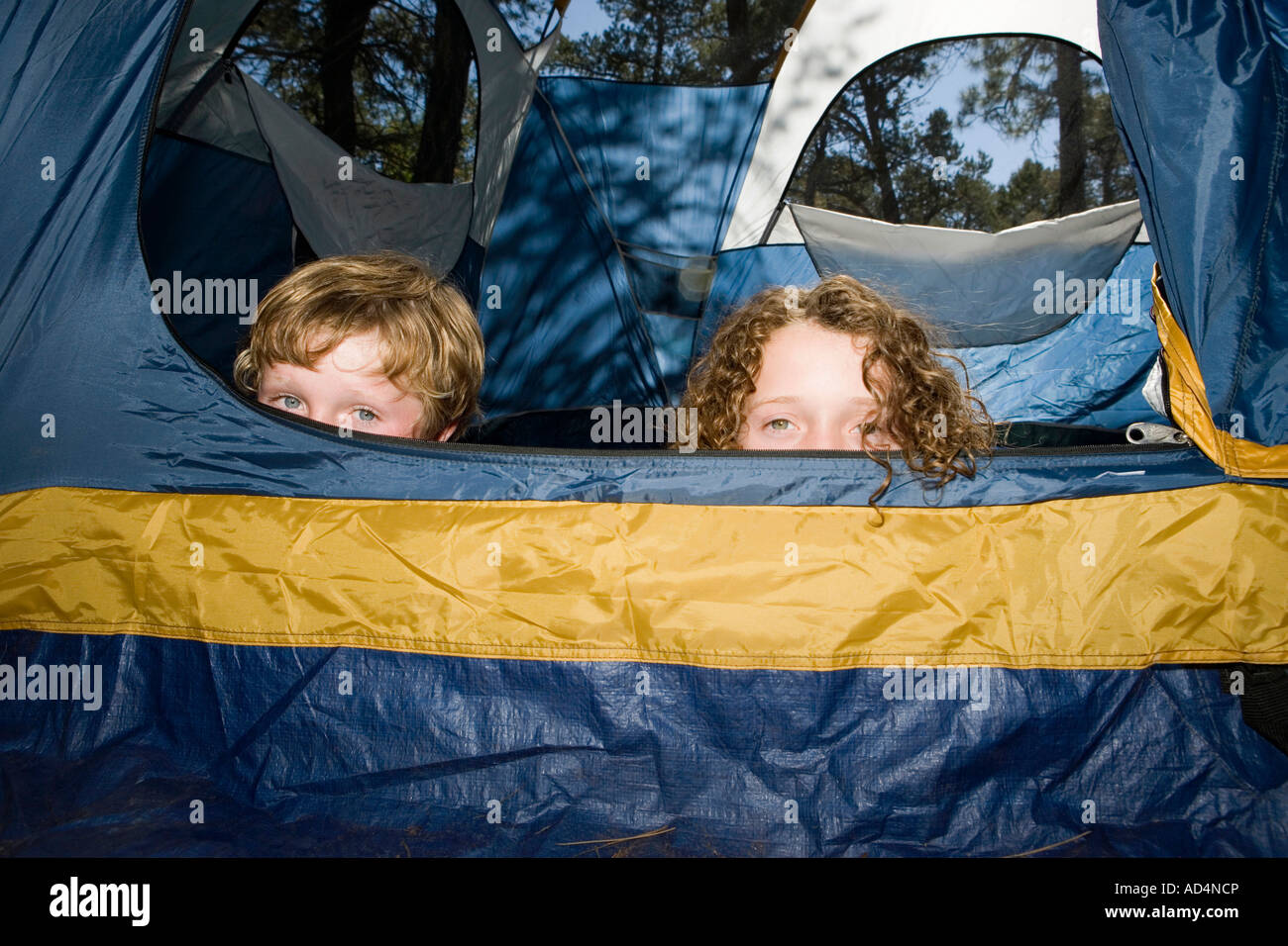 Deux garçons se cacher dans une tente Banque D'Images