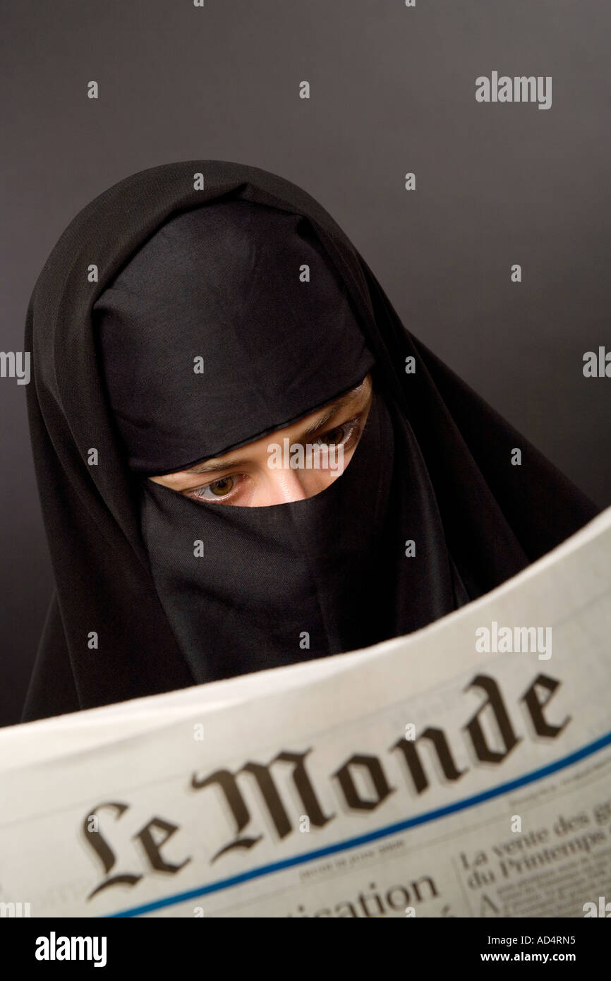 Femme musulmane portant un hijab burqa lire le journal français Le Monde Banque D'Images