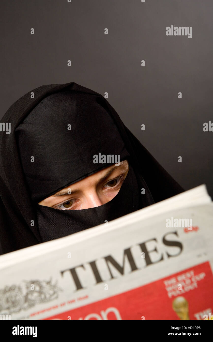 Femme musulmane portant un hijab burqa lire le journal The Times Banque D'Images