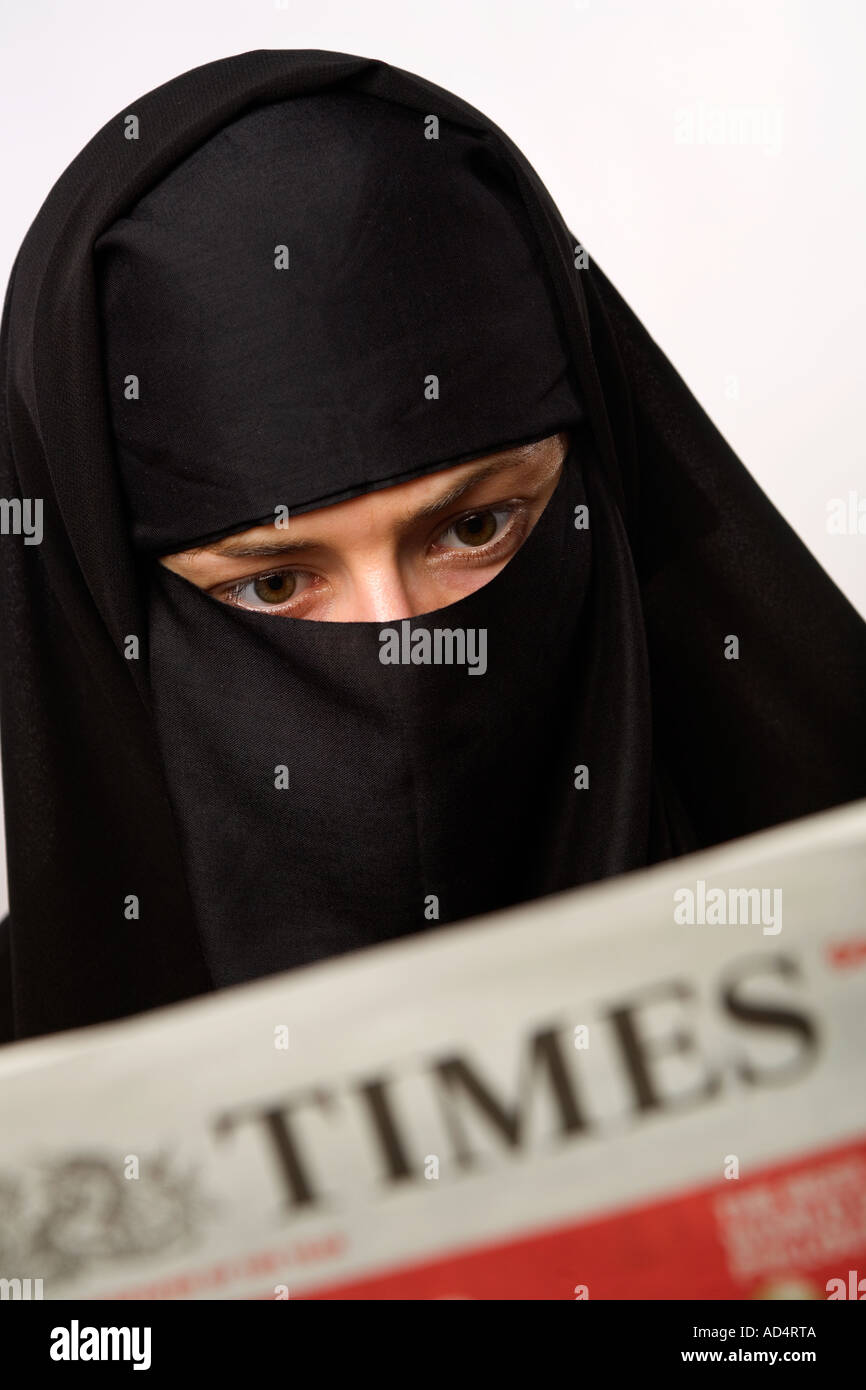 Femme musulmane portant un hijab burqa lire le journal The Times Banque D'Images