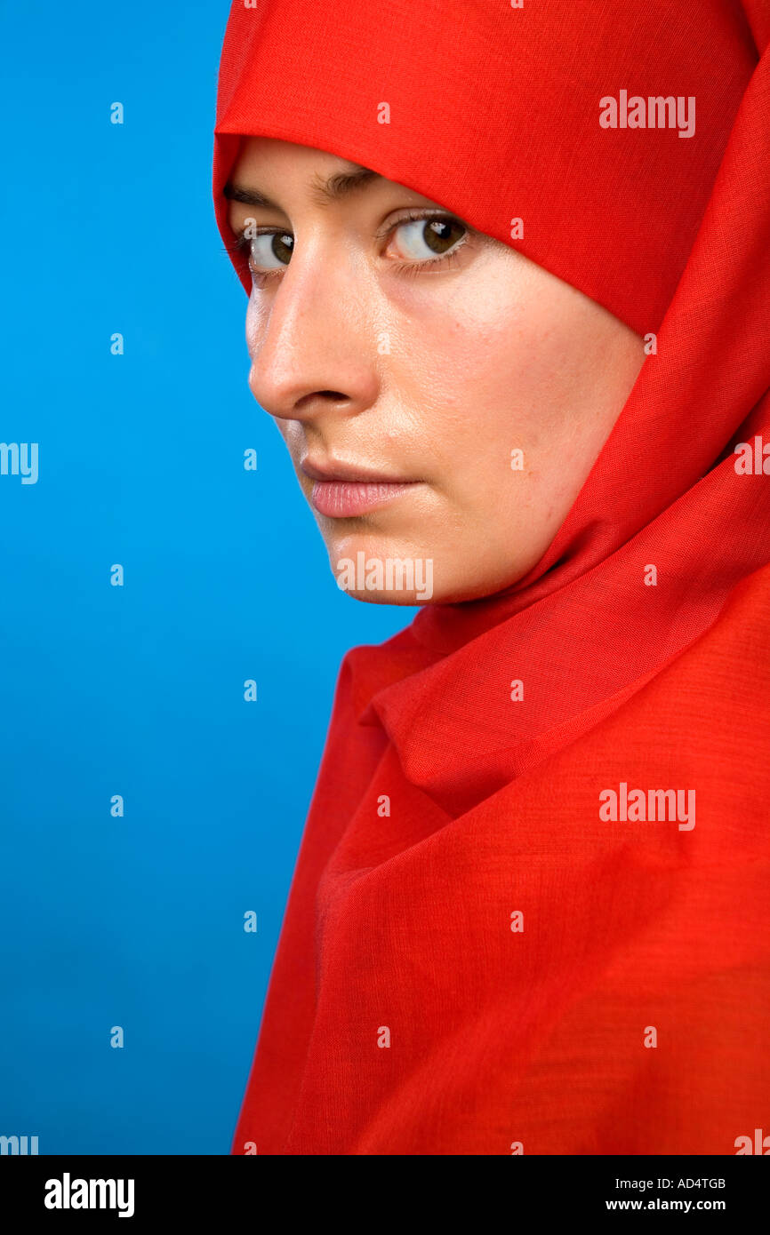 Close up profile head shot d'une femme musulmane dans un hijab rouge avec les yeux regardant droit devant Banque D'Images