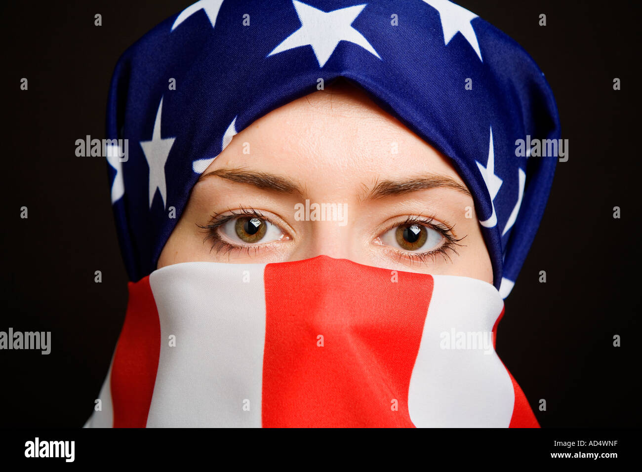 Femme musulmane portant un drapeau USA US américain comme un hijab burqa avec un fond noir Banque D'Images