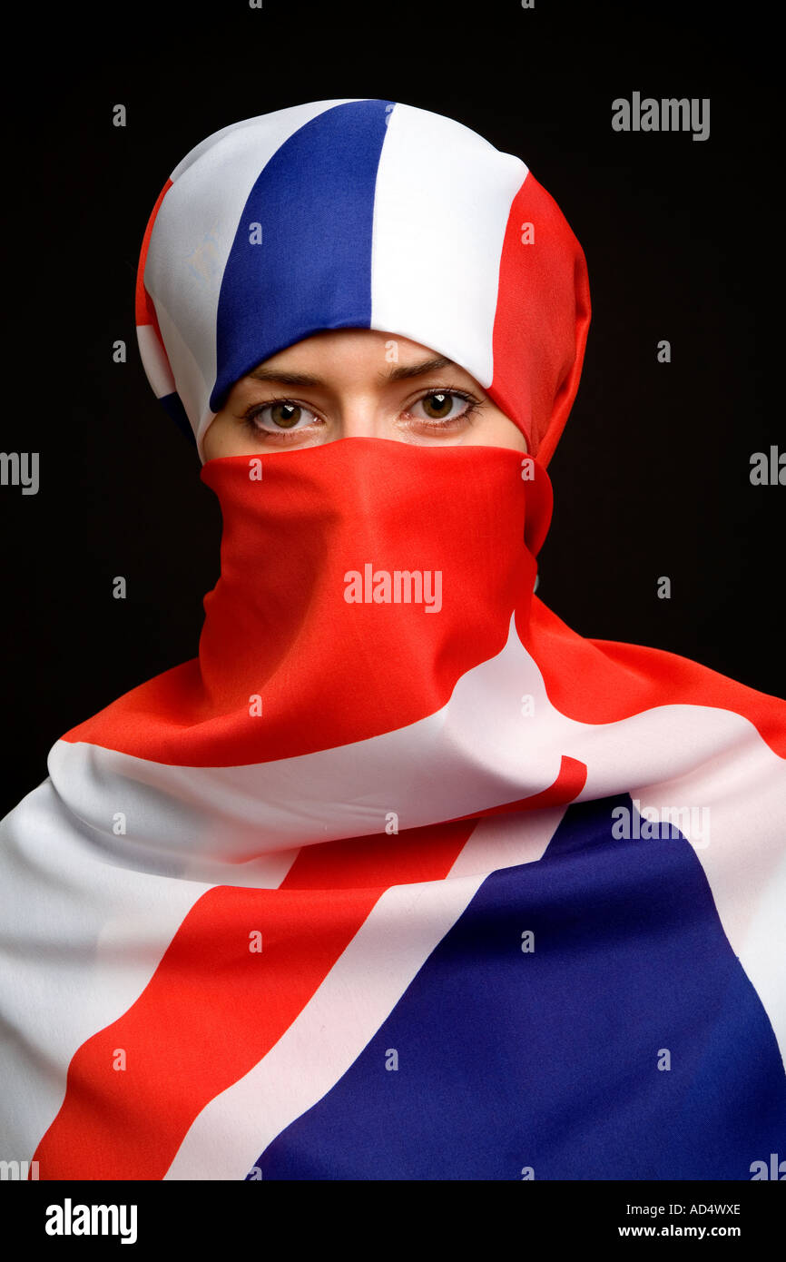 Femme musulmane portant un drapeau Union Jack comme un hijab burqa avec un fond noir Banque D'Images