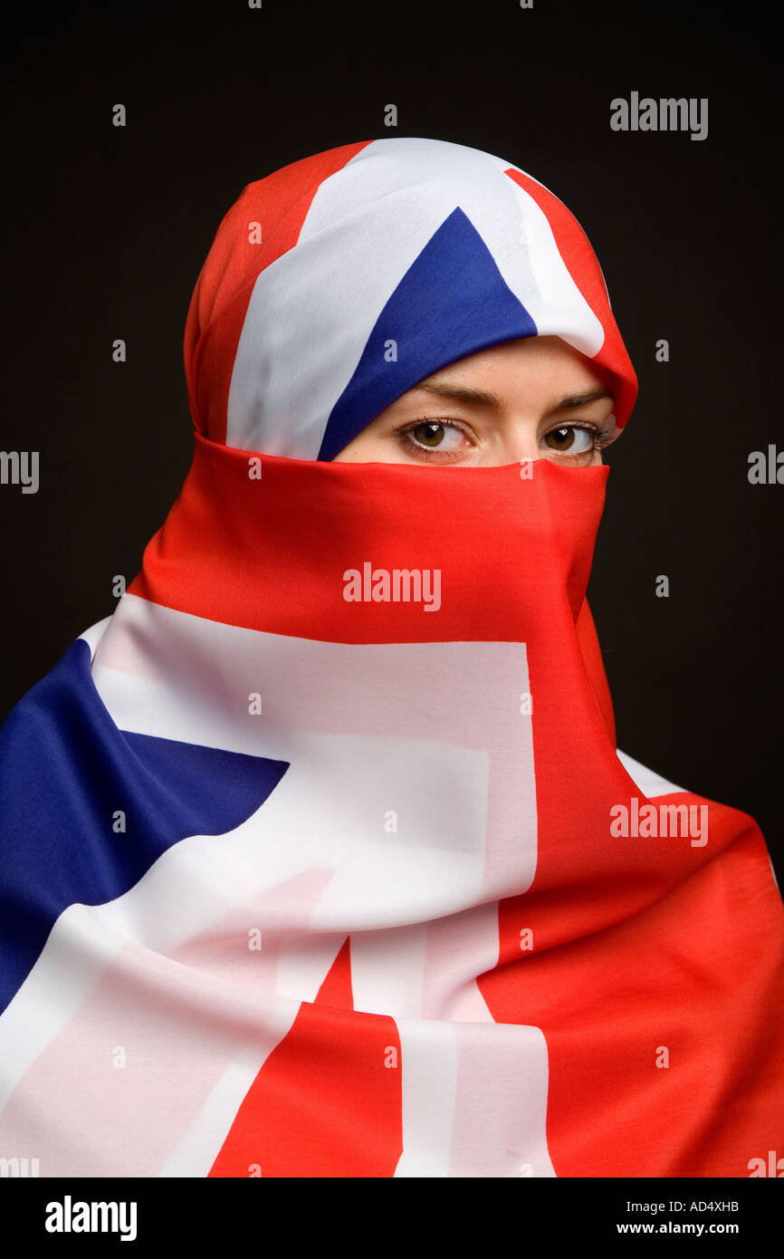 Femme musulmane portant un drapeau Union Jack comme un hijab burqa avec un fond noir Banque D'Images