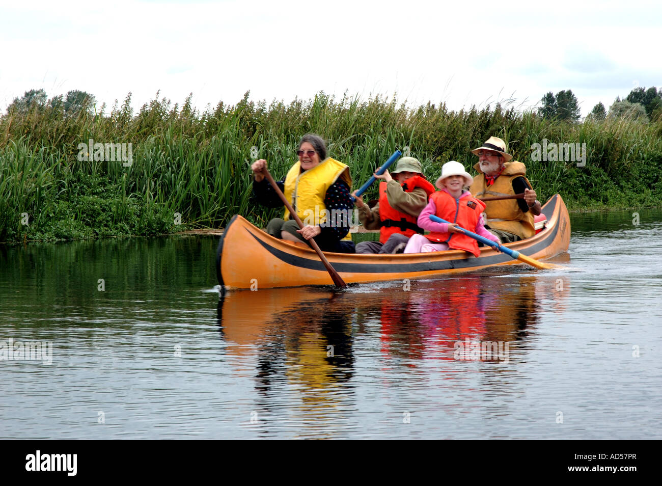 Famille canadienne de Pagaie canoë sur la rivière Waveney sur la frontière, Norfolk Suffolk Broads National Park Banque D'Images