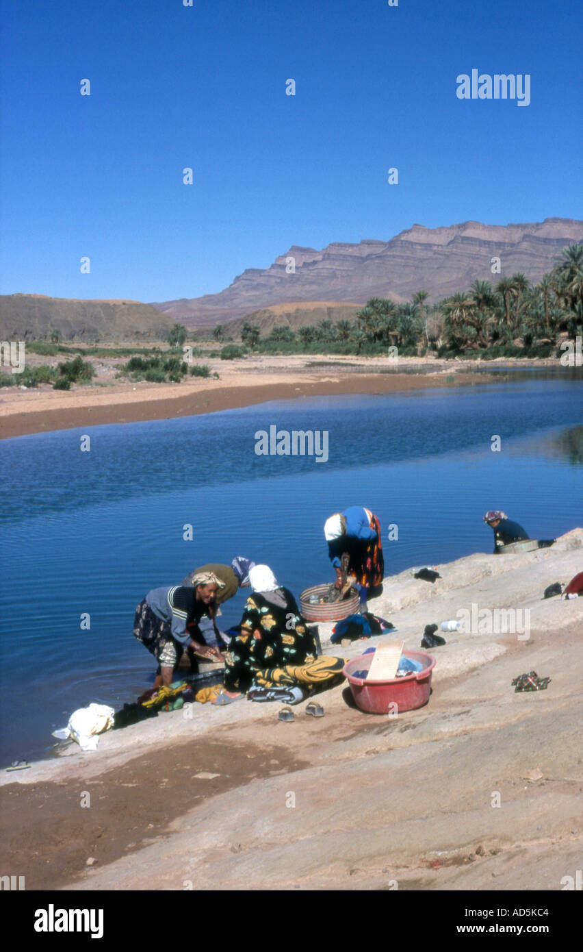 Les femmes lavent leur linge dans la rivière Draa Draa, Maroc Banque D'Images