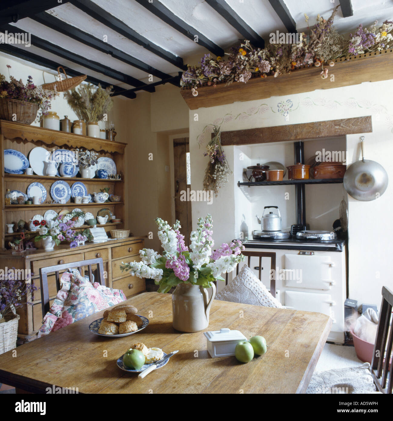 Aga blanc four en chalet cuisine avec table et vaisselier en pin avec pot  de fleurs roses et blanches Photo Stock - Alamy