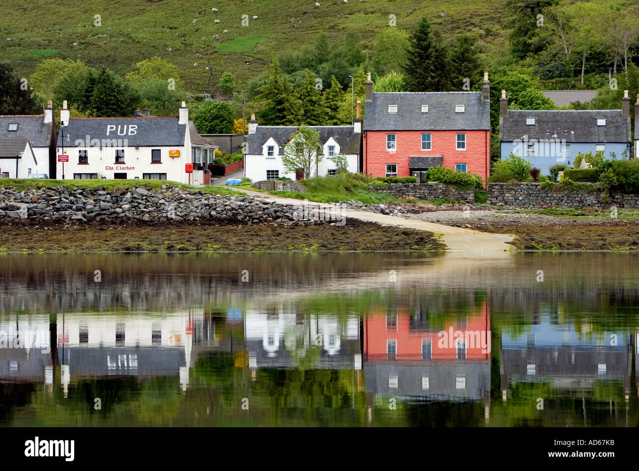 Maisons peintes de couleur reflète dans l'eau dans le village de Dornie, près de Le Château d'Eilean Donan, dans l'ouest de Ross-shire, Highlands d'Ecosse Banque D'Images