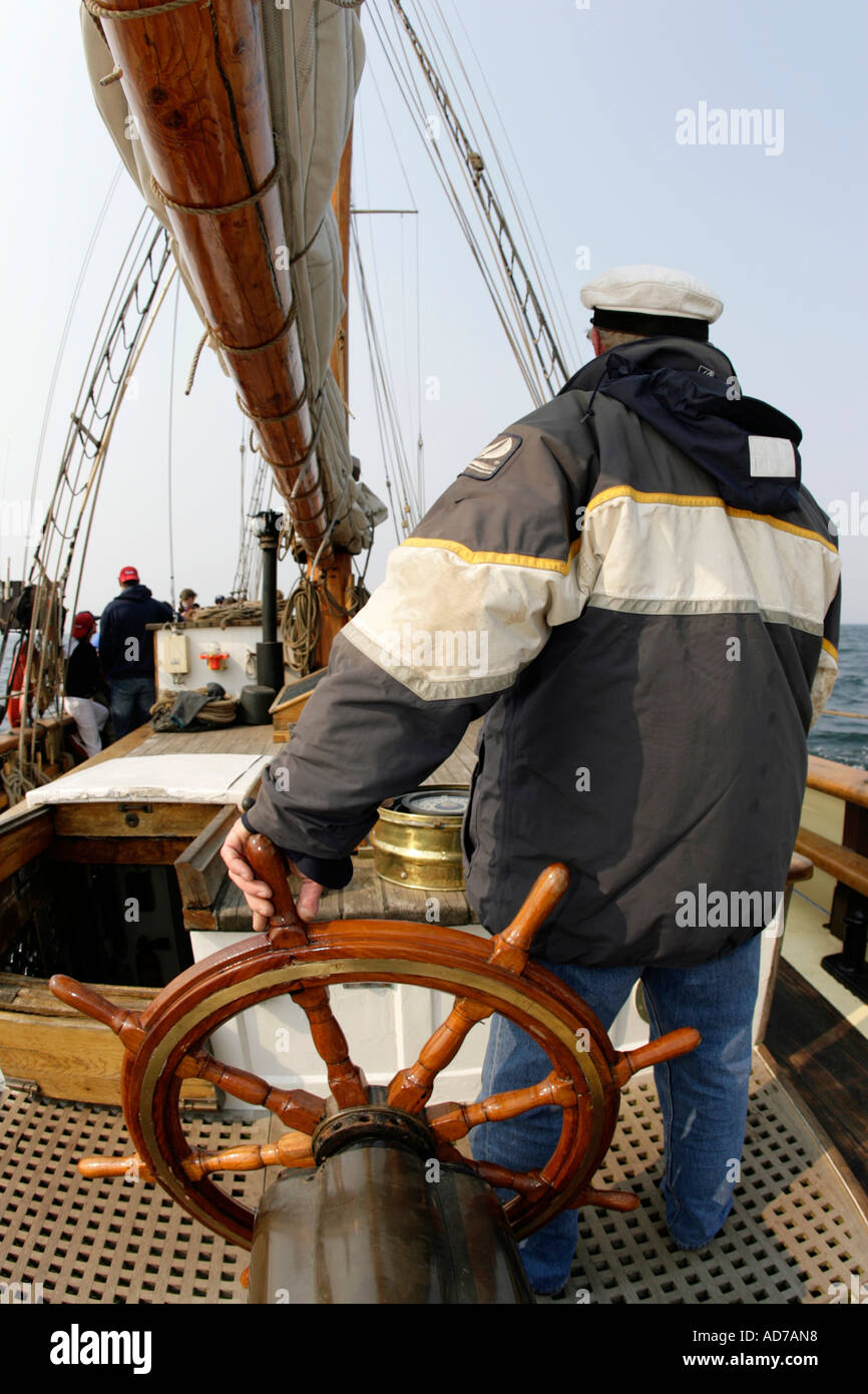 Le capitaine navigue sur son bateau à voile Banque D'Images