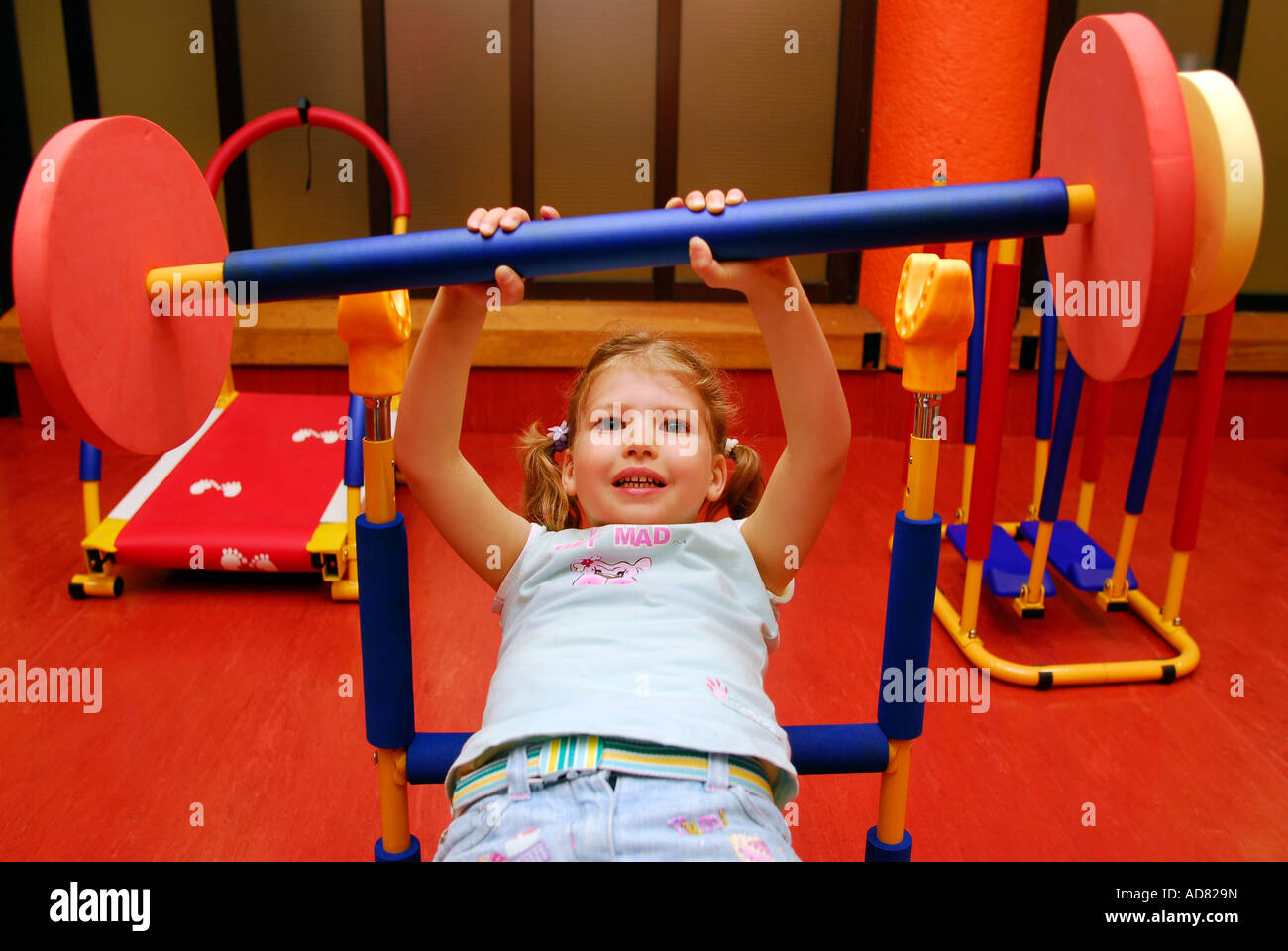 4 ans, fille d'un centre de loisirs, à l'aide de poids en creche, Brixton, London, UK. Banque D'Images