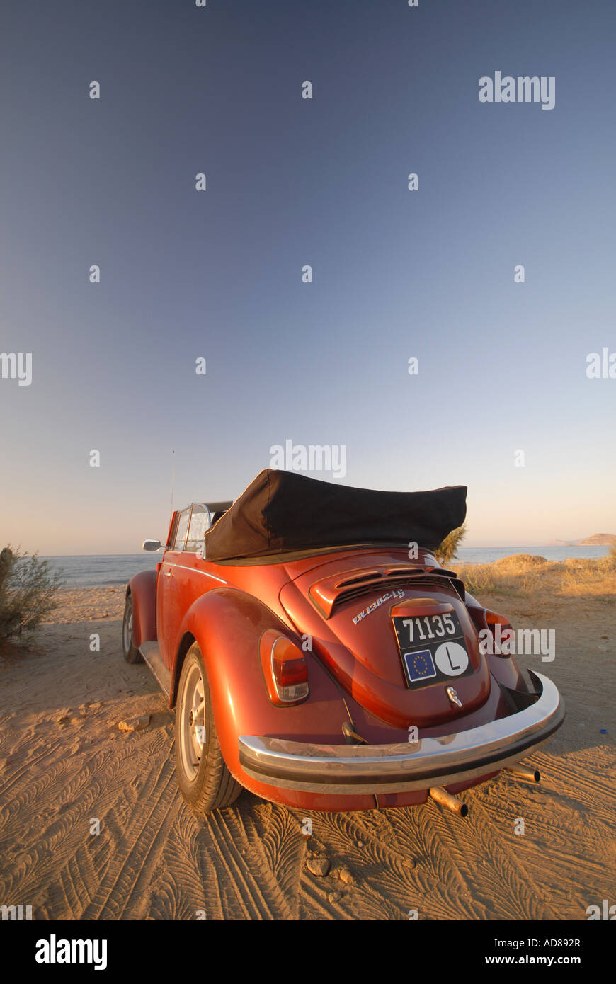 Volkswagen Beetle convertible orange sur la plage Banque D'Images