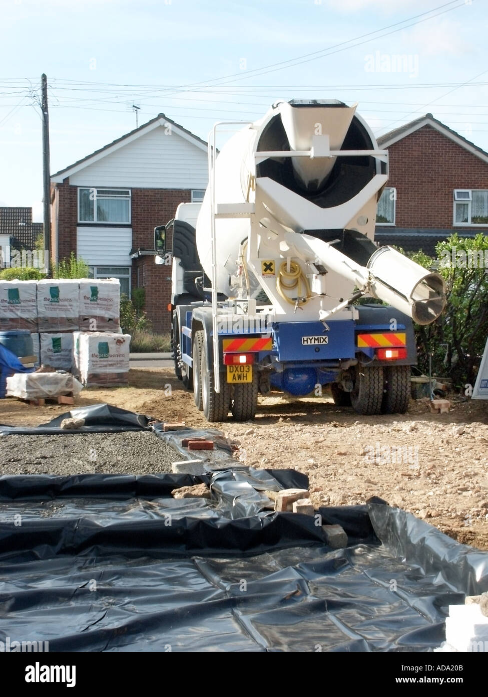 Le malaxeur à béton Camion Camion de livraison sur chantier de construction inverse pour verser de plus concret sur la membrane plastique preuve humide England UK Banque D'Images