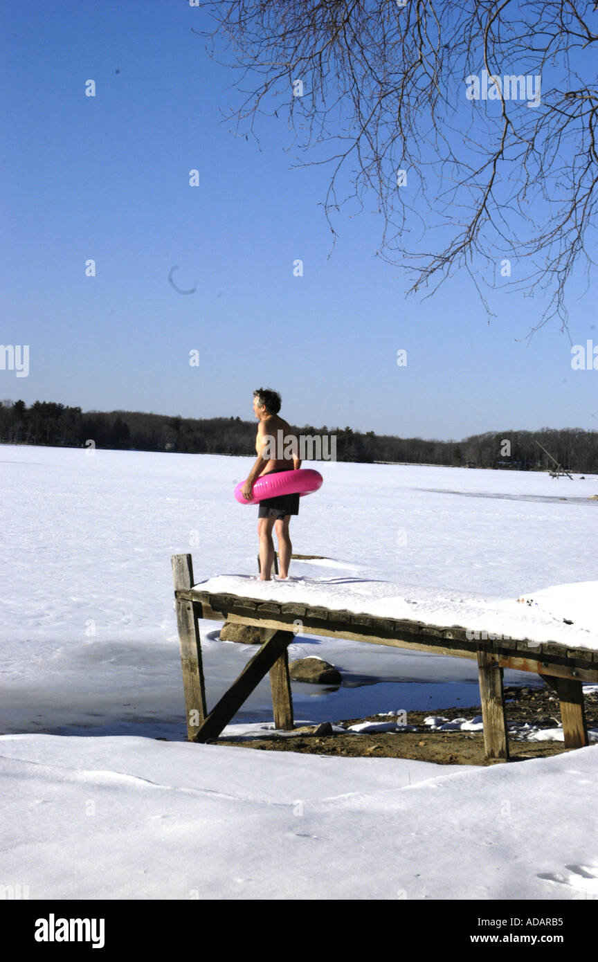 Homme avec tube intérieur prêt à nager à regarder lac gelé Banque D'Images