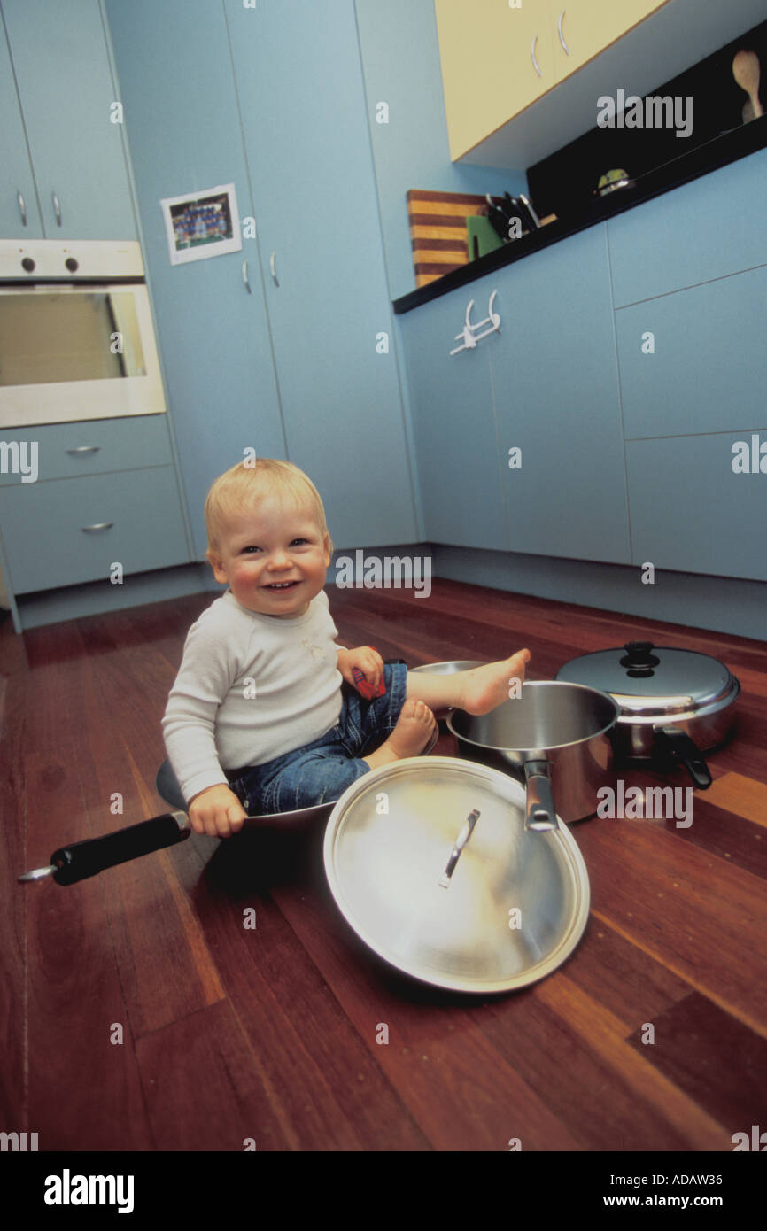 1 ans baby boy sitting dans des pots dans la cuisine Banque D'Images