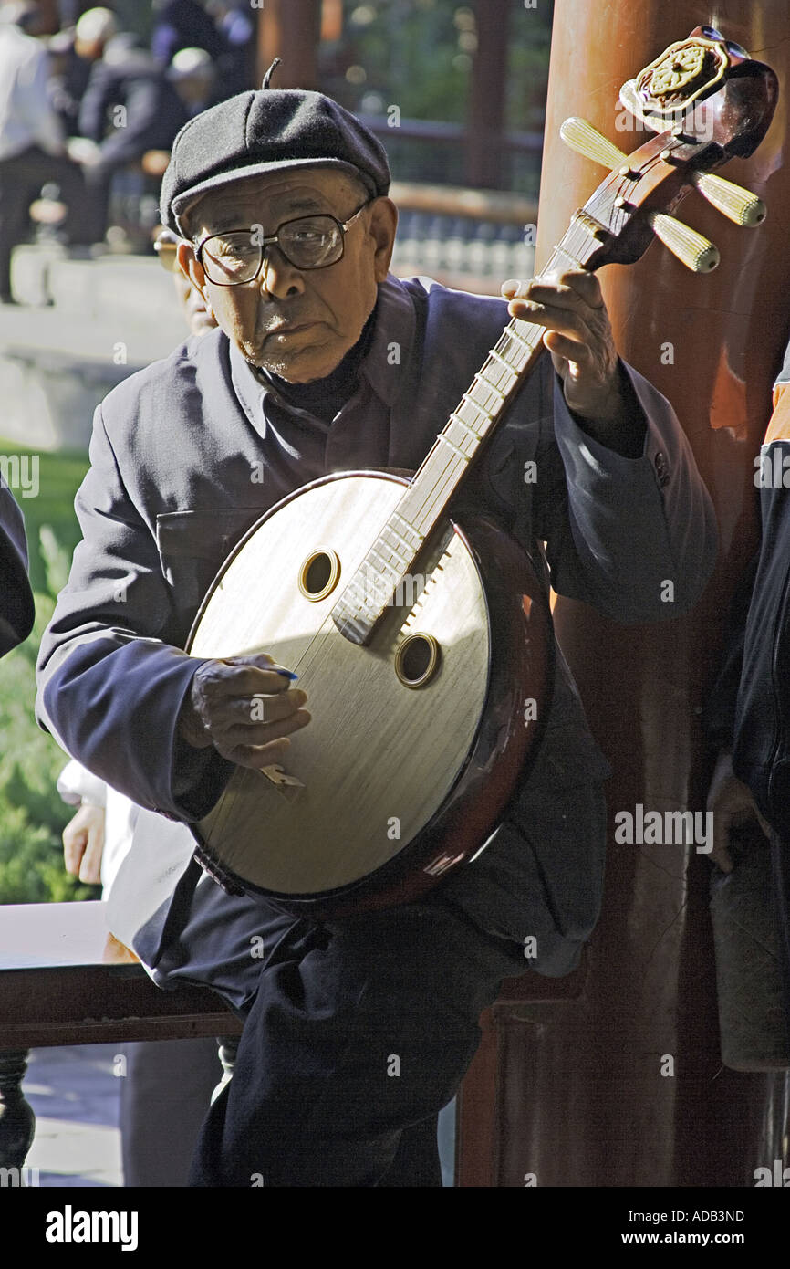 BEIJING CHINE Personnes âgées gentleman Chinois à jouer du pipa à quatre cordes au Temple du Ciel Park Banque D'Images