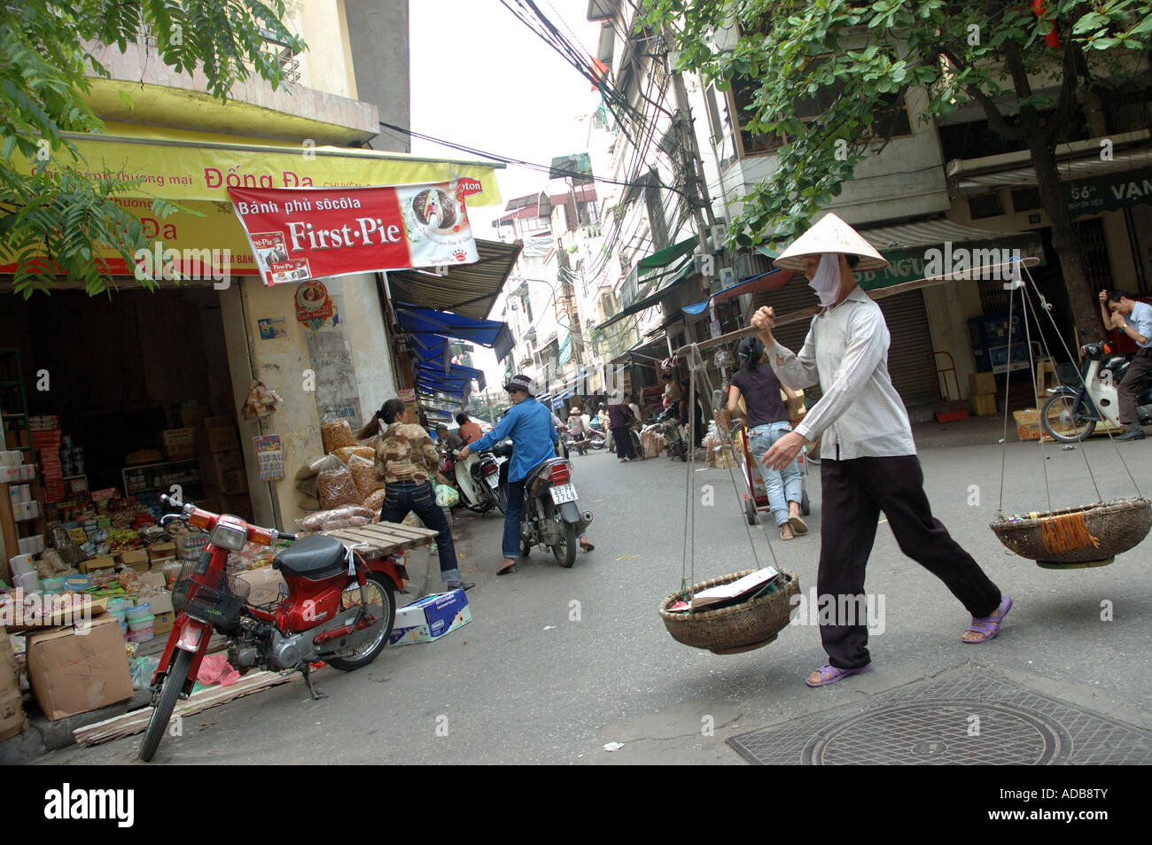 La vente de marchandises de dame panier sur coin de rue de Hanoi au Vietnam Banque D'Images