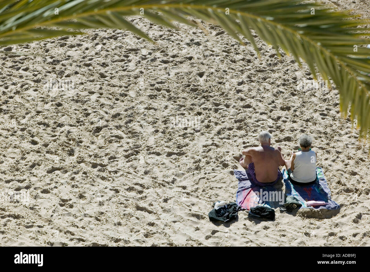Couple de retraités sunbathing on beach Banque D'Images