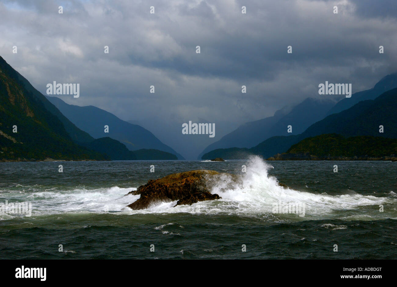 Vagues se brisant sur les rochers à l'entrée de son douteux Fjordland ile sud Nouvelle Zelande Banque D'Images