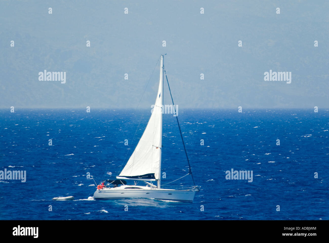 Vue horizontale d'un petit yacht blanc naviguant dans la mer Méditerranée - c'est à inclinaison latérale du port avec la force du vent Banque D'Images