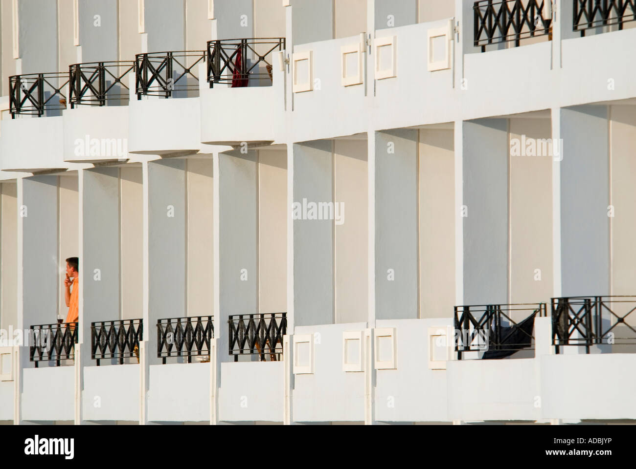 Résumé horizontale close up d'un homme solitaire debout sur son balcon de l'hôtel ayant une cigarette tranquille le soir soleil. Banque D'Images