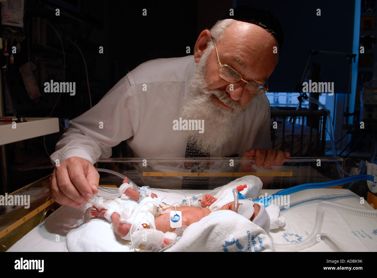 Un médecin de Haredi vérifiant le nourrisson prématuré dans un incubateur de l'unité de soins intensifs néonataux du centre médical Shaare Zedek West Jérusalem Israel Banque D'Images