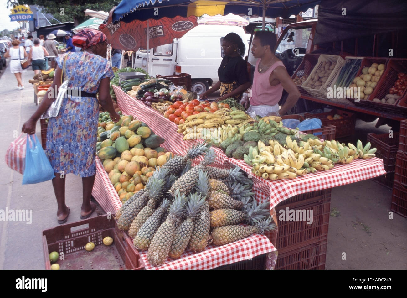 Sainte Anne les étals du marché aux côtés de la vente trottoir large gamme de fruits et légumes dans un affichage en couleur Banque D'Images