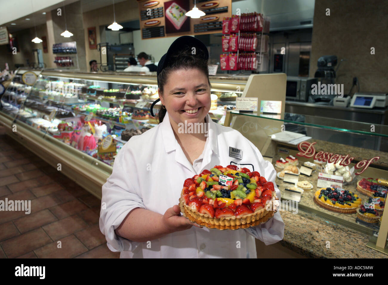 Responsable Boulangerie A Un Grand Supermarche Montre Un Gateau Garni De Fruits Frais Dans Le Magasin Photo Stock Alamy