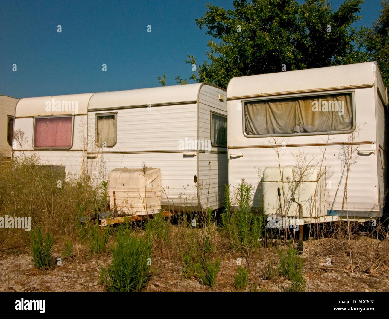 Trois caravanes abandonnées dans une rangée dans un champ désert Banque D'Images