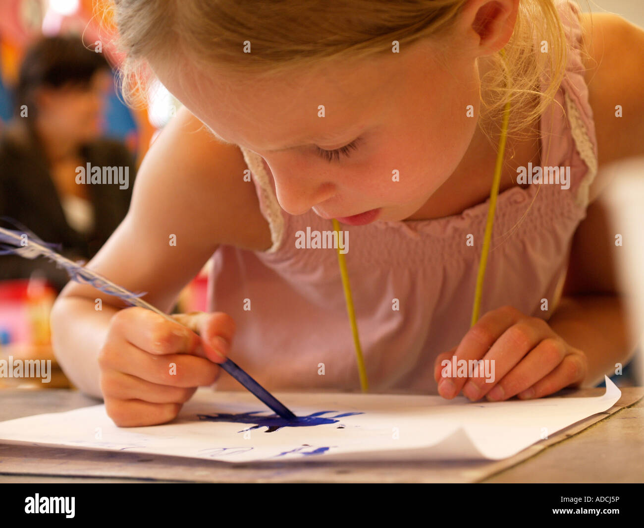 Petite fille enfant concentré à l'aide de plume suranné, plume d'oie pour l'écriture et le dessin à l'encre bleue Banque D'Images