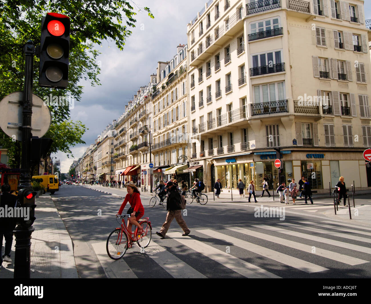 Scène de rue avec une femme en robe rouge sur rouge location traversant la rue paris france Banque D'Images