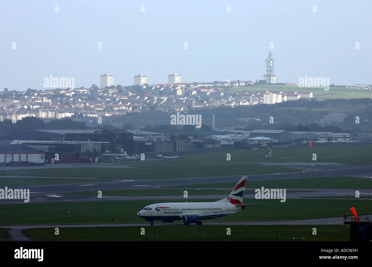British Airways attend l'avion de décoller de l'aéroport d'Aberdeen dans la soirée avec la ville en arrière-plan Banque D'Images