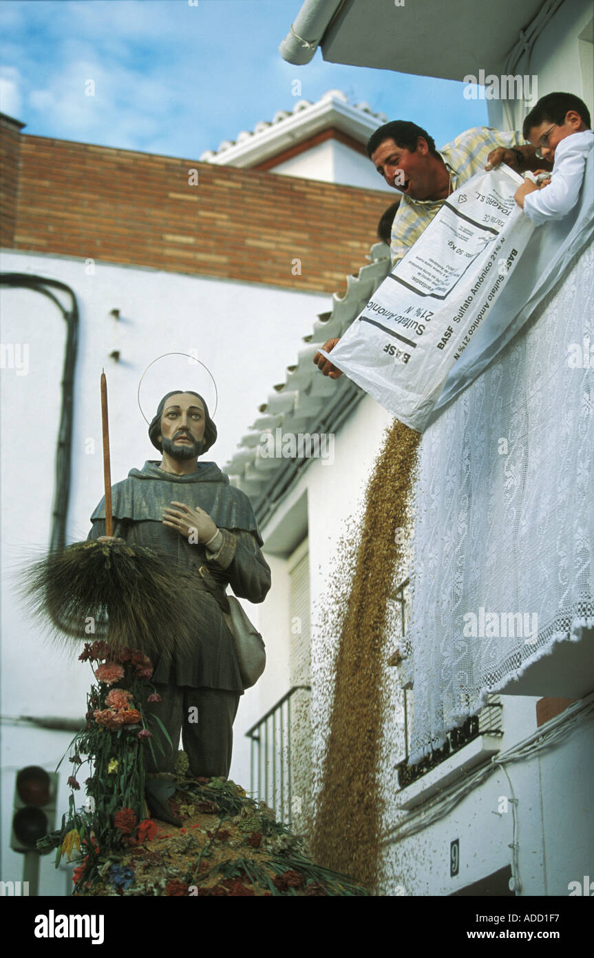 Verser les gens de blé qui donne sur une statue de San Isidro à la Fiesta de San Isidro Periana, Province de Malaga Espagne Banque D'Images