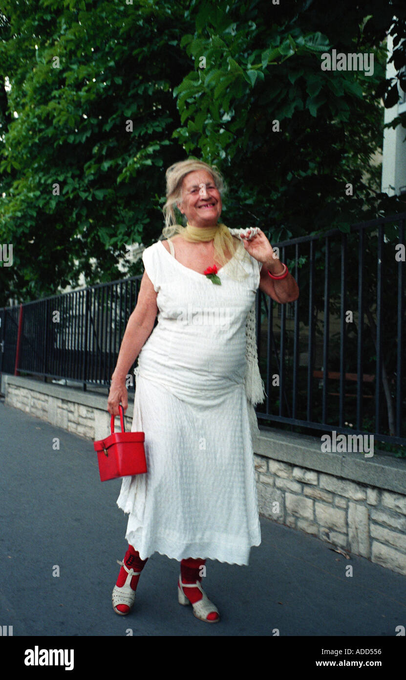 Une vieille femme en robe blanche et rouge accessoires monte l'élégante rue  Andrasszy à Budapest Hongrie Photo Stock - Alamy