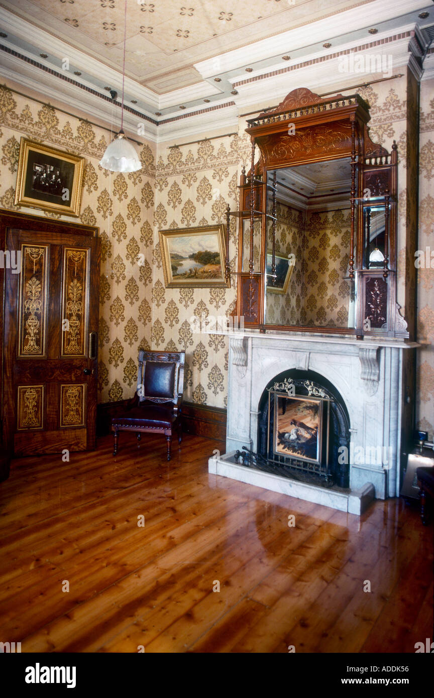 Le marbre blanc cheminée victorienne avec un miroir au-dessus et porte au pochoir salon parquet poli Melbourne Australie Banque D'Images