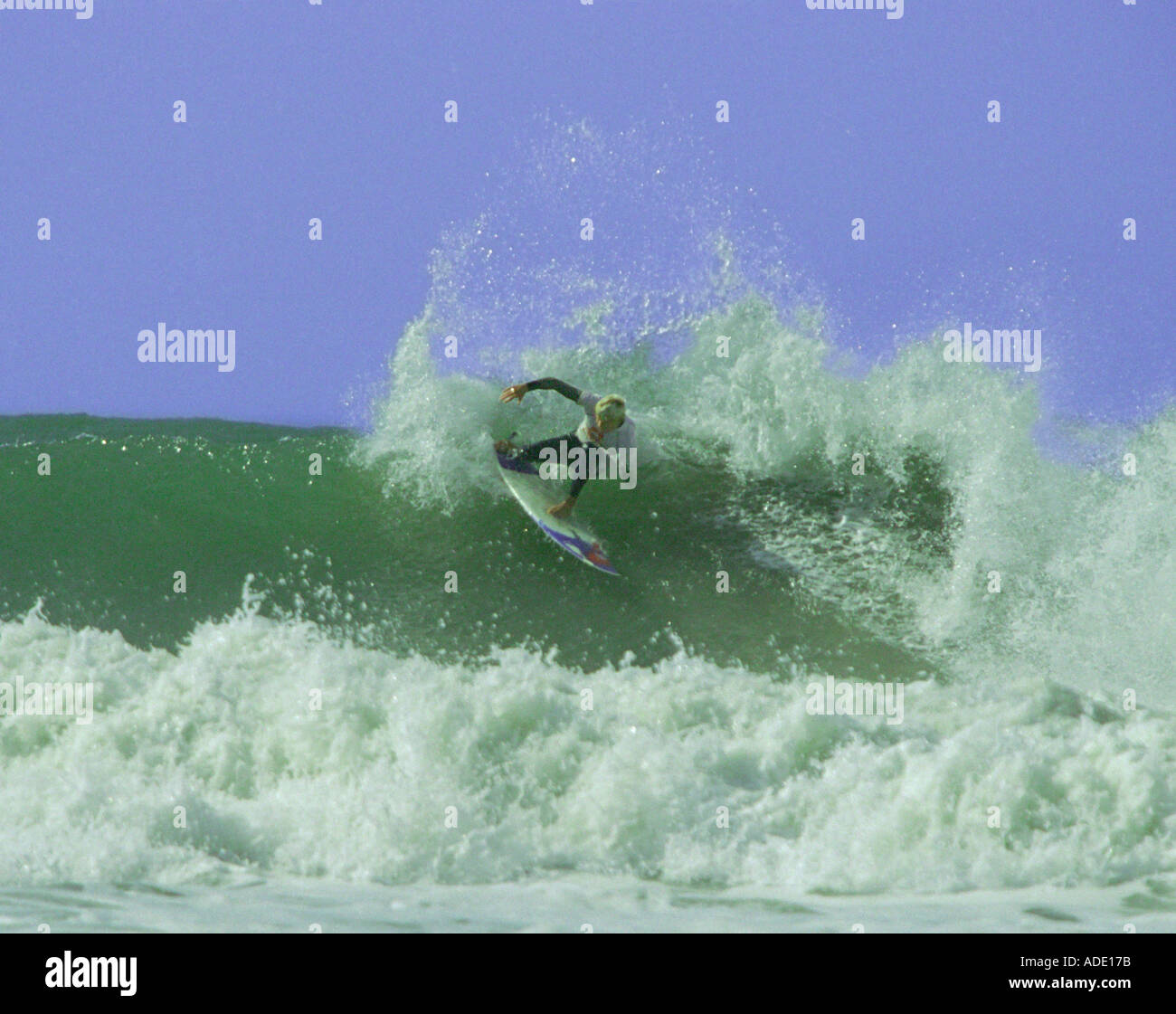 Un internaute sur la lèvre à manœuvrer avec vitesse de vol de pulvérisation tout en entrant dans un virage serré à la baie de Croyde Devon, Angleterre Banque D'Images