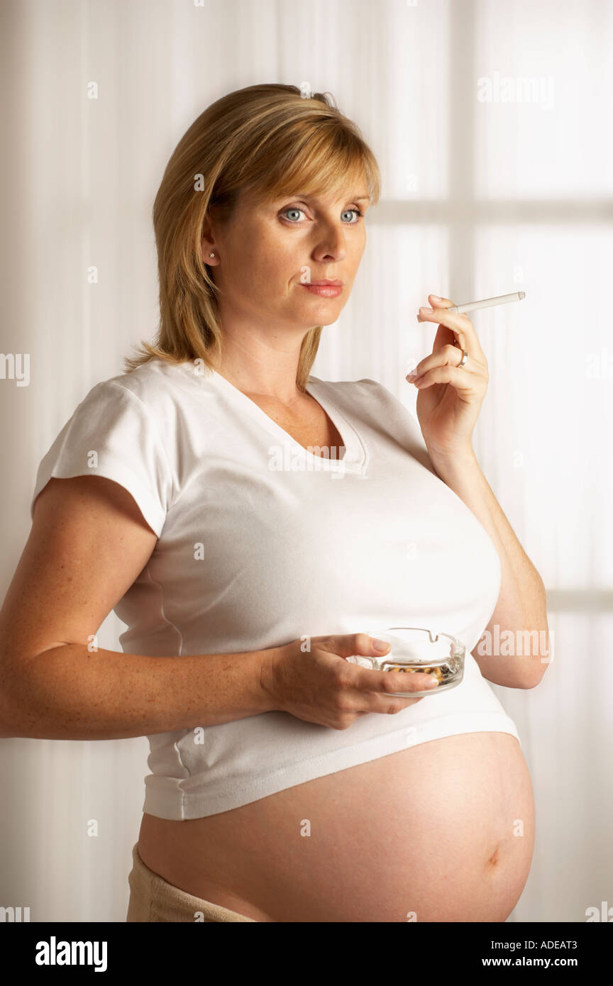 Jolie JEUNE FEMME ENCEINTE EN BONNE SANTÉ CIGARETTE Banque D'Images