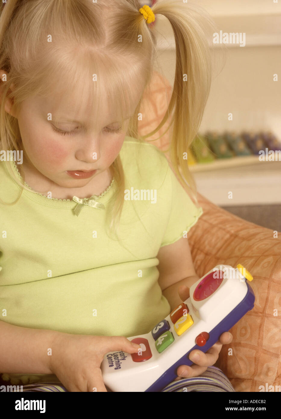 Jeune fille jouant avec des jouets en plastique téléphone Banque D'Images