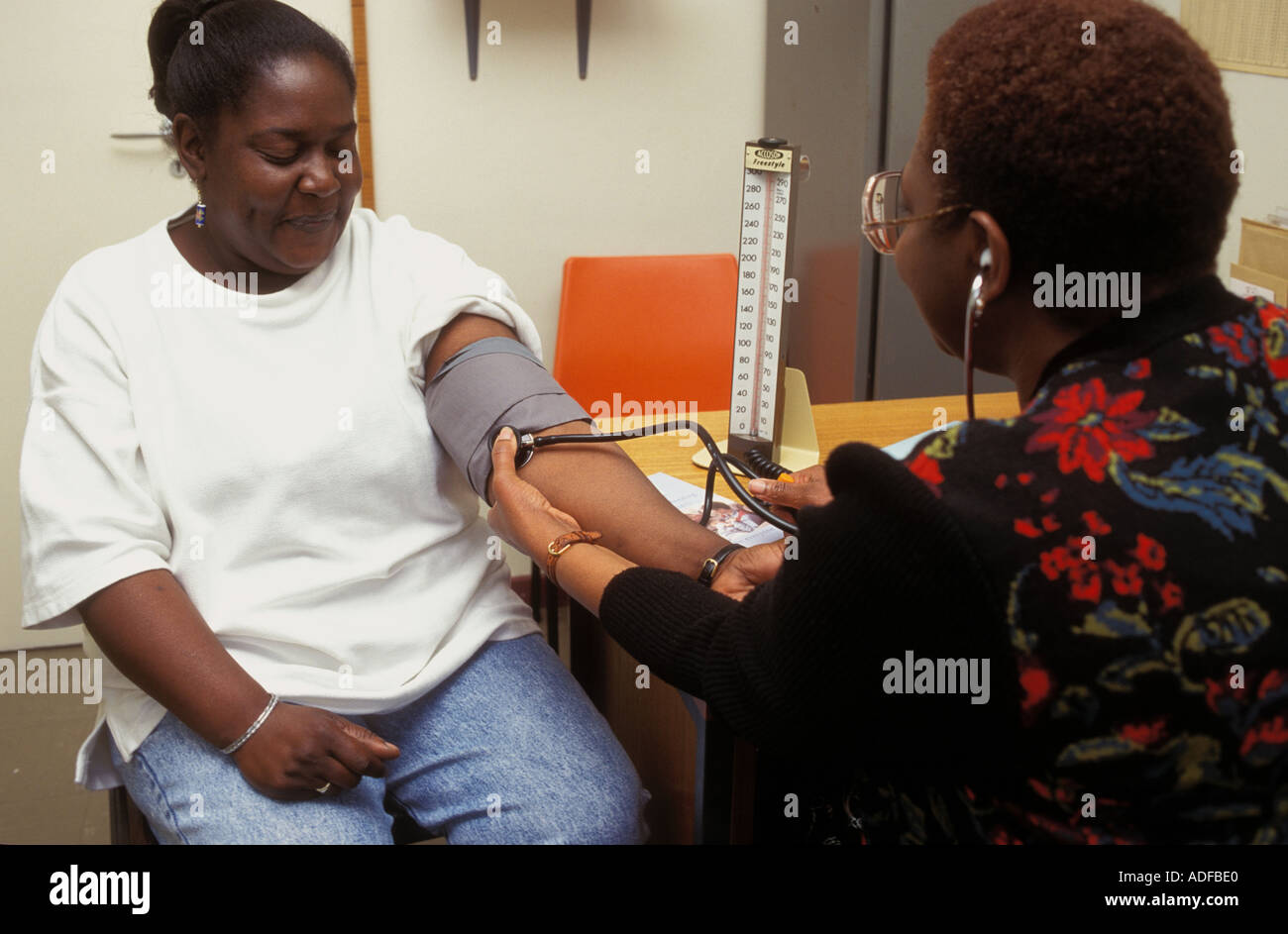 Visiteur santé prendre une femme enceinte a une tension artérielle au cours des affaires courantes les vérifier. natal Banque D'Images