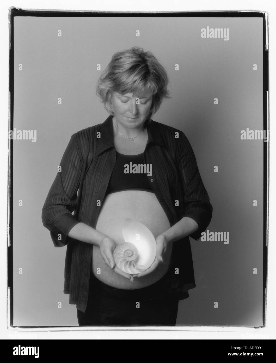 Pregnant woman holding nautilus shell Banque D'Images