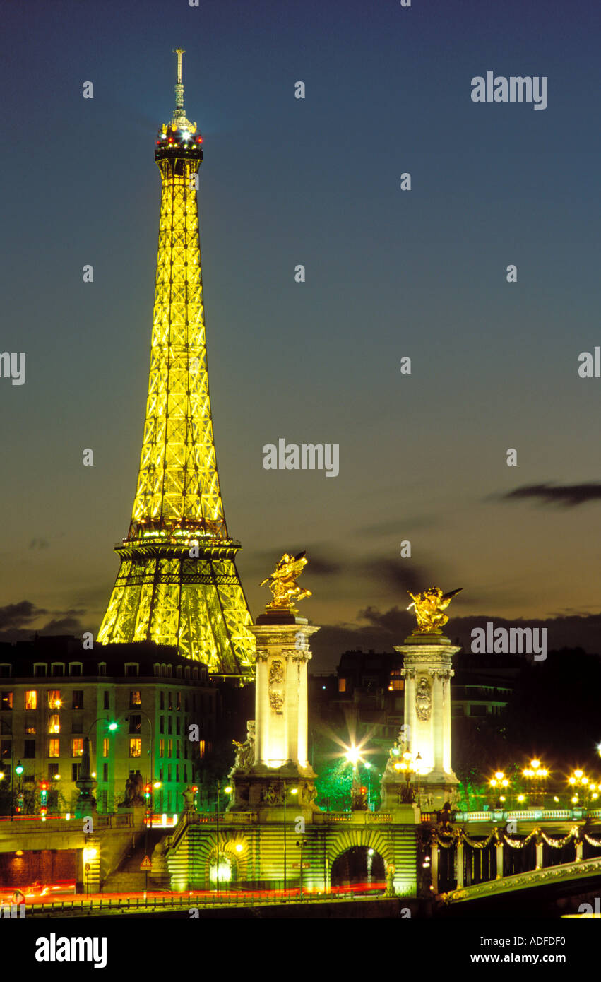 France Paris La Tour Eiffel illuminée la nuit et le Pont Alexandre III Banque D'Images