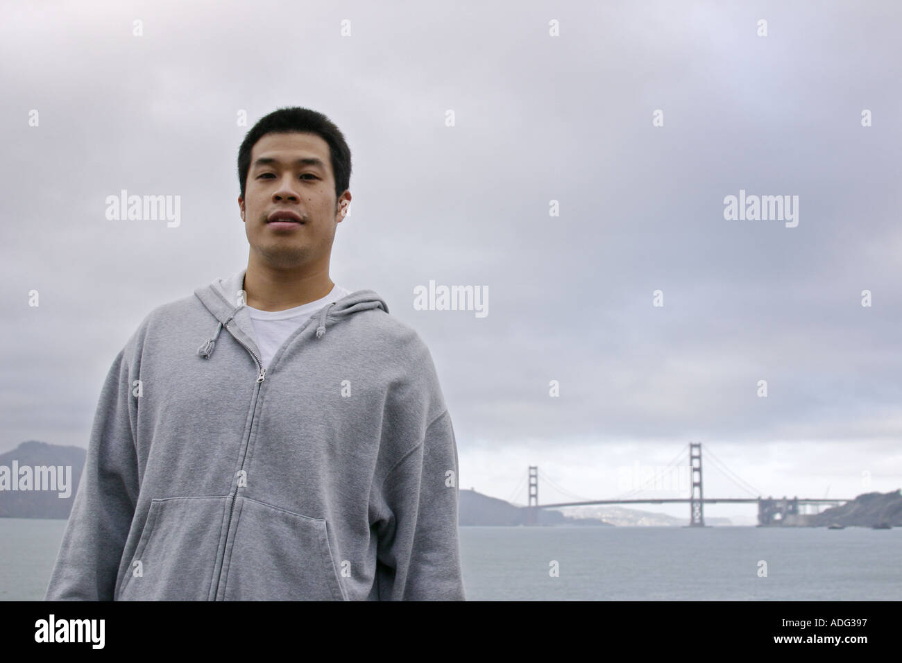 Portrait d'un jeune homme asiatique avec le Golden Gate Bridge en arrière-plan San Francisco California Banque D'Images