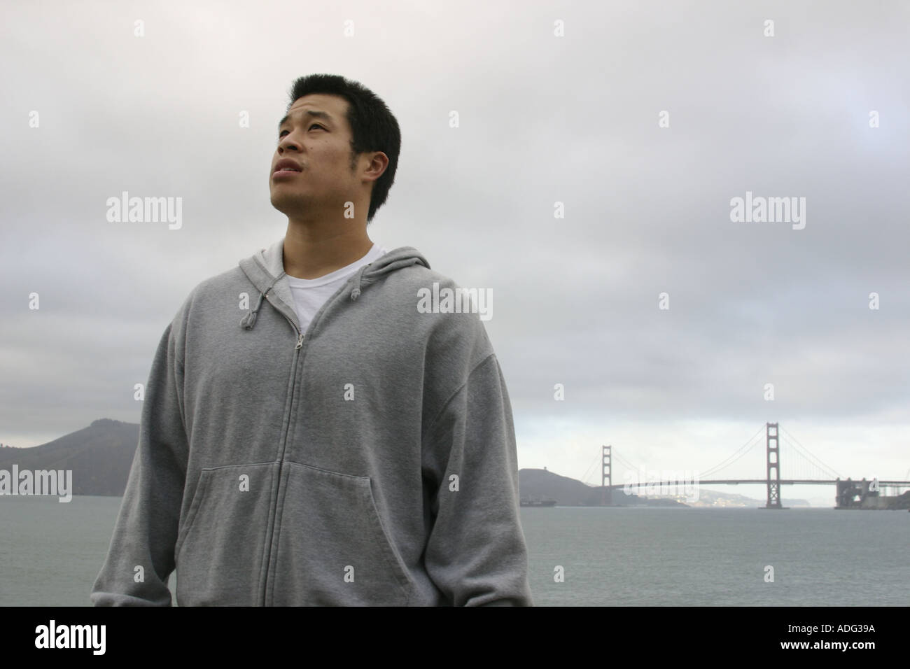 Portrait d'un jeune homme asiatique avec le Golden Gate Bridge en arrière-plan San Francisco California Banque D'Images