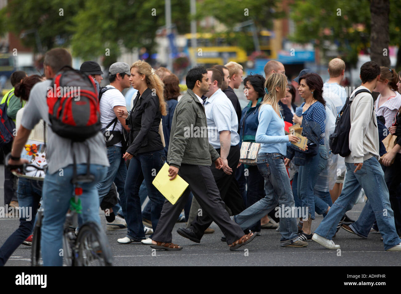 Les personnes qui traversent une intersection achalandée sur oconnell street dublin pendant les heures de pointe tout en cycliste attend Banque D'Images