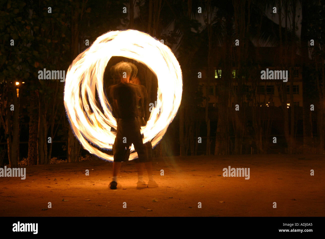 Man spinning fire poi clubs de nuit motif de cercles Banque D'Images