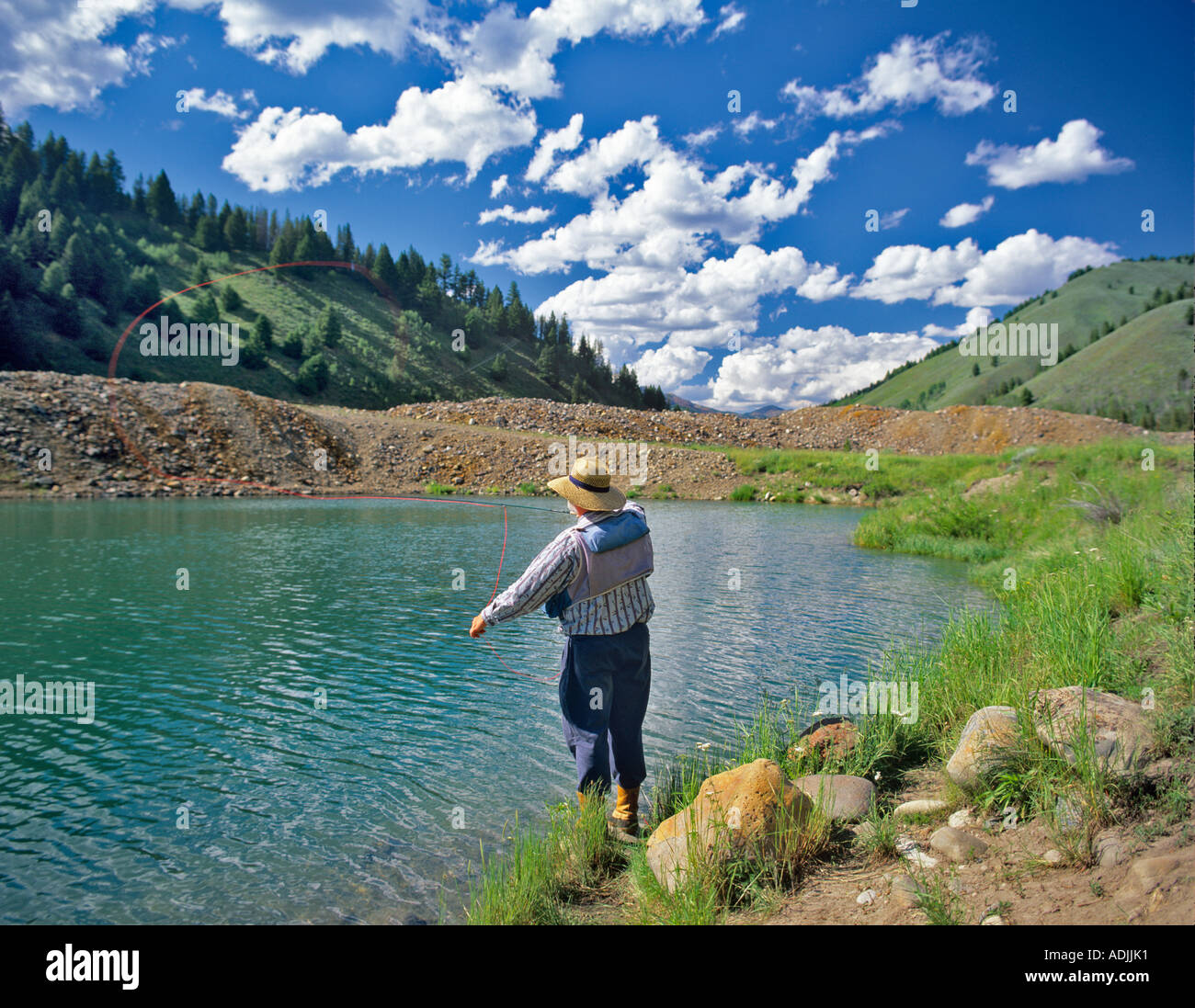 Fly fisherman casting à truite sur étang dans l'Idaho Sawtooth National Recreation Area Banque D'Images