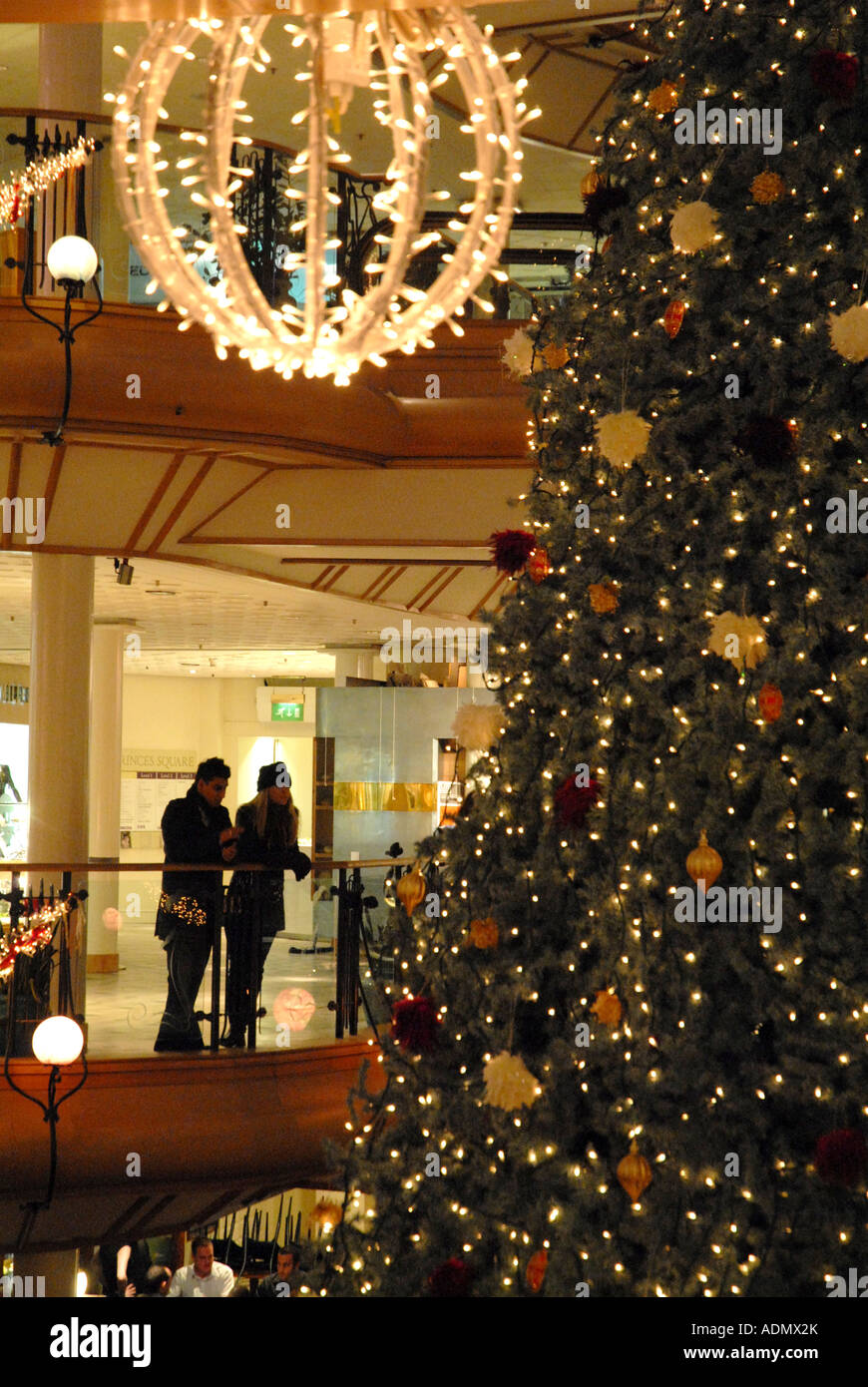 Jeune couple penché sur rail à la Princes Square Shopping Centre, Glasgow.L'Ecosse. Décembre Banque D'Images