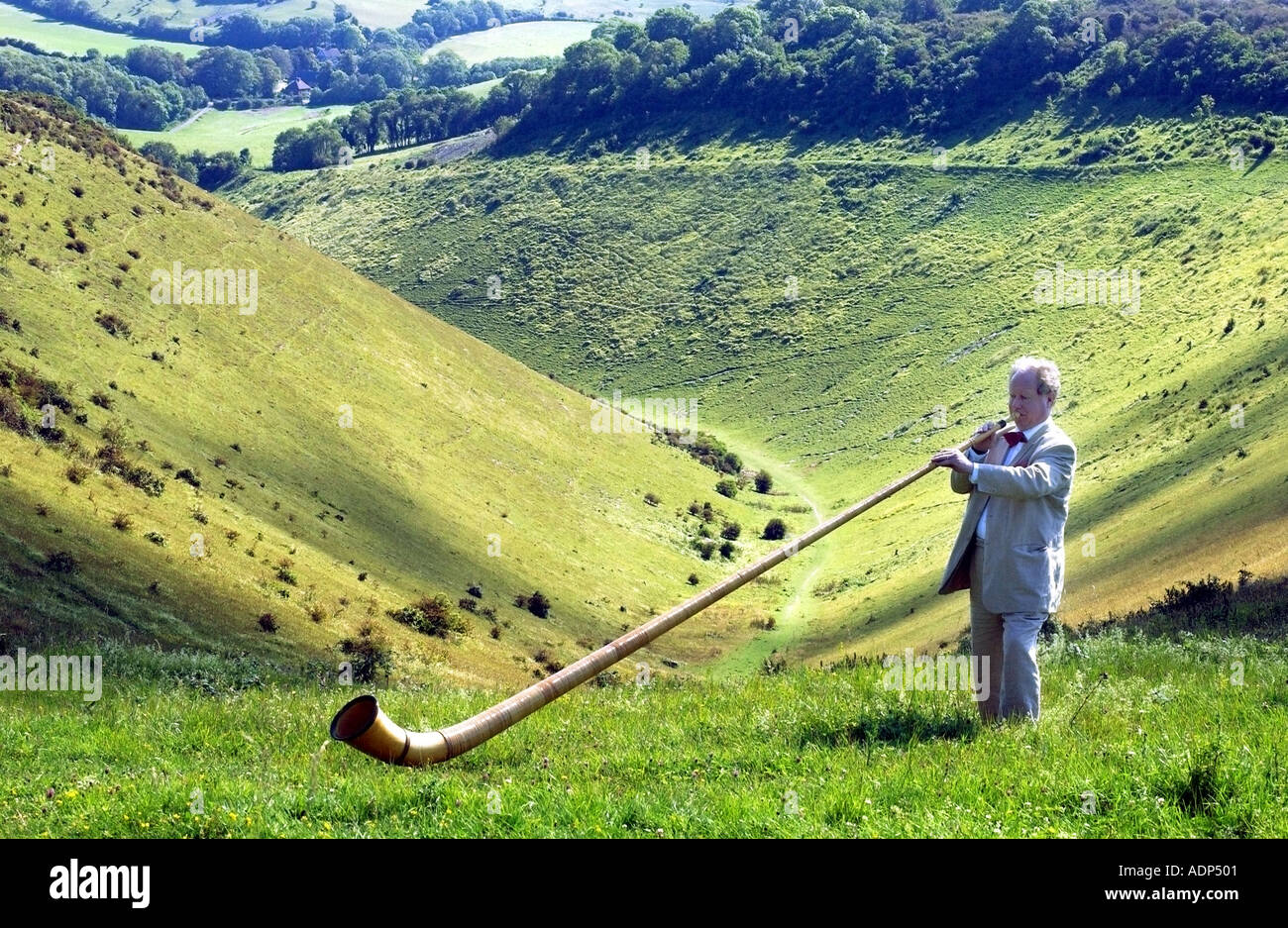 Un homme jouant le cor des alpes ou cor des Alpes Suisse étrange instrument de musique sur le 'South Downs' 'National Park' Banque D'Images