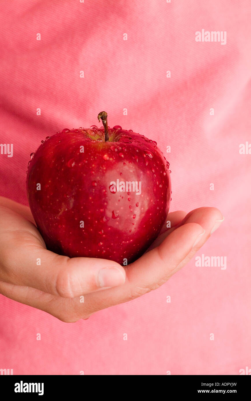 Une femme mûre main tenant une pomme rouge délicieuse à la sinfully bon Banque D'Images