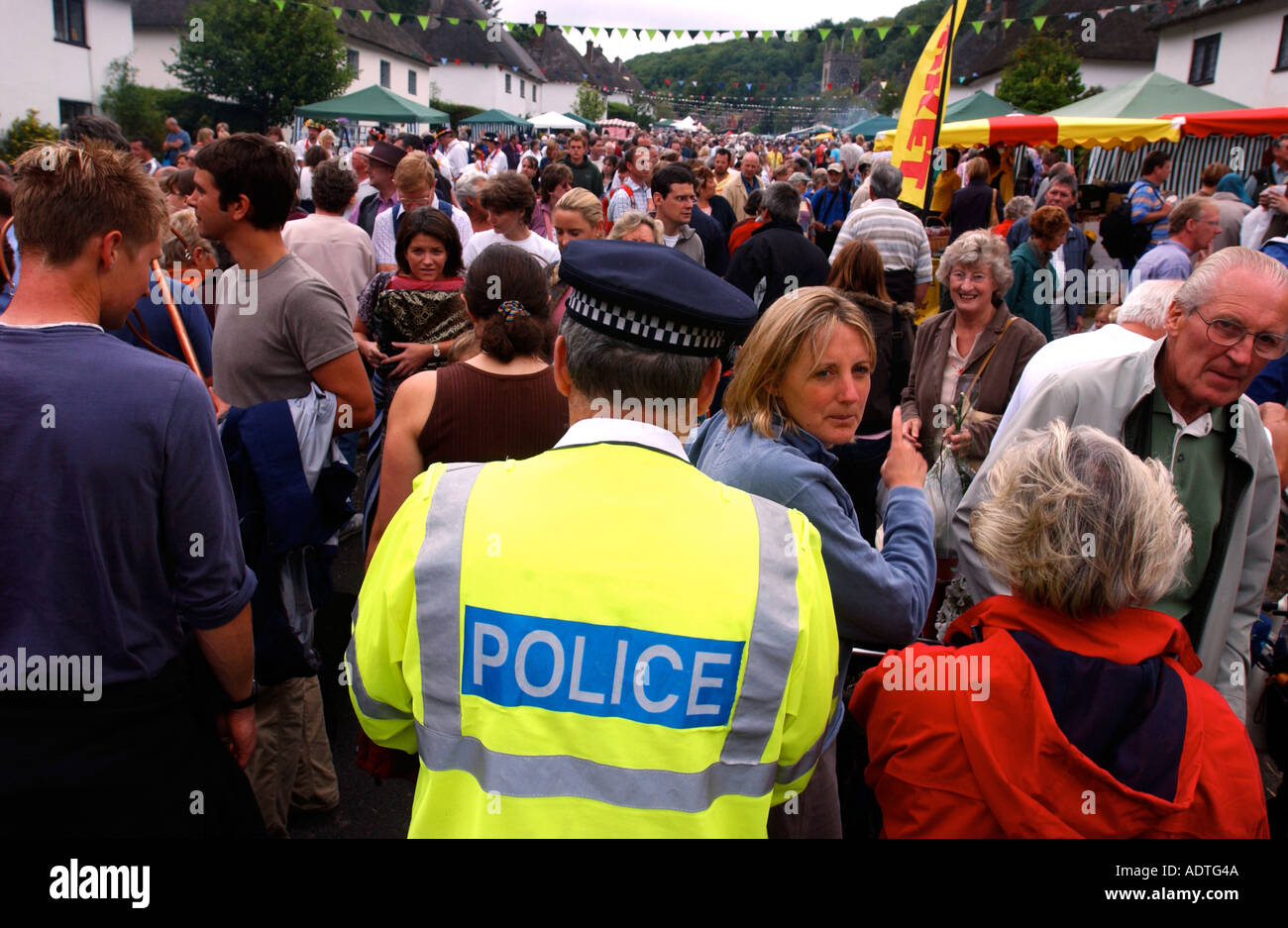 Policier patrouillant dans une foule à la Milton Abbas foire de rue dans le Dorset England UK Banque D'Images