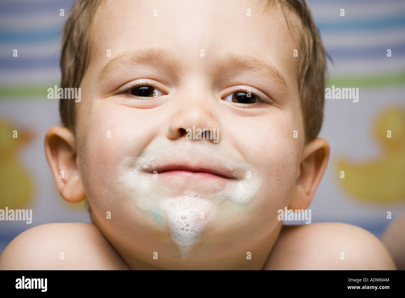 Boy smiling avec du dentifrice sur le visage Banque D'Images